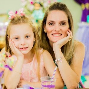 Mãe e filha sorriem para foto.