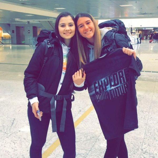 Luana e Maria Clara estão no aeroporto, sorrindo para a foto